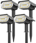 Four black Solar Spotlight Outdoor 1000 Lumens 64 LEDs IP67 Waterproof Landscape Lighting in a set, mounted on stakes.