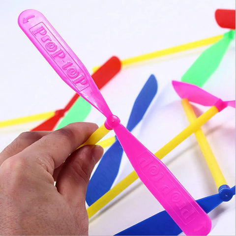 Hand holding a pink propeller from Flying Helicopter Toy Set With 20 Propellers And 20 Rods Hand Rub Helicopter For Outdoor Fun Kids Gift