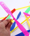 Hand holding colorful Flying Hand Helicopter Toy Set for kids and parties, 100 piece bundle with 50 propellers and 50 rods.