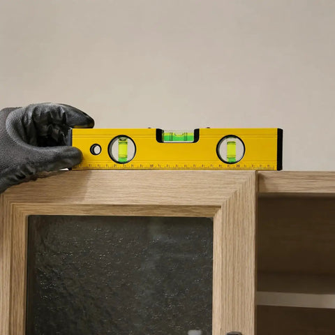 Spirit Level, Aluminum Alloy, 250mm on a cabinet, held with gloved hand for precise leveling.