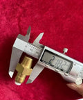 Brass 3/8-in NPT thermal relief valve for pressure washer pump, shown with a digital caliper.