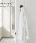 Kickass Single Wall Hook Built With Rock Solid Aluminum And Rich Black Walnut Wood For Hanging Heavy Winter Coats Bath Towels Backpacks And Daily Essentials In Entryways Or Bathrooms with a white robe hanging on it.