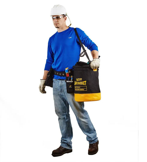 Worker carrying Safe Bucket With 250 Lb Load Rating Drawstring Vinyl Construction on job site, black and yellow design with leather sleeve.