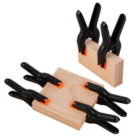 Ten 4.5-inch plastic spring clamps with orange tips clamping wooden blocks