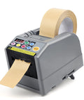 Automatic Tape Dispenser And Ribbon Cutting Machine Offering No Sweat Quick Precision Trimming Portability For Shipping Packing Schools And Retail Stores Smooth Manual Override With Lightweight Ergonomic Build Design gray tape dispenser with visible tape roll and control panel.