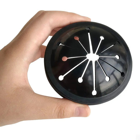 Hand holding a black rubber splash guard from Four Pack Garbage Disposal Splash Guards And Stopper Set For Three And One Eighth Inch Drains.