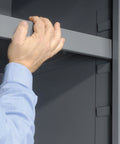 Hand adjusting a shelf in the Heavy Duty Workshop Storage Rig With Sixty Eight Durable Yellow Plastic Bins And Fully Adjustable Interior Shelves.