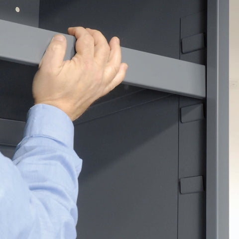 Hand adjusting a shelf in the Heavy Duty Workshop Storage Rig With Sixty Eight Durable Yellow Plastic Bins And Fully Adjustable Interior Shelves.