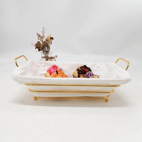 Gold Wire Serving Basket For Fruit And Bread with linen liner, filled with colorful cupcakes on a white countertop.