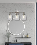 Bathroom vanity with three light fixture featuring Four Pack Clear Seeded Glass Lamp Shade Replacements For Ceiling Fans Chandeliers Pendant Lights Vanity Lights And Kitchen Island Fixtures Fits Two And One Eighth Inch Fitter 4.76 Inch Diameter 5.47 Inch High mounted above round mirror on terrazzo wall.