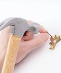 Hand using hammer to attach nail to hanger from DIY Picture Hanging Hardware Kit 220 Piece Brass Finish Set With 24 Ten Pound, 14