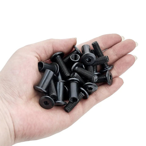 Hand holding M8x25mm black barrel nuts from Zero Sweat Assembly 100 pack for woodworking and mechanical assembly.