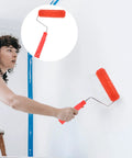 Woman using Decorative Textured Wall Paint Roller With Ergonomic Handle Creates Realistic Wood Grain Effects on white wall.