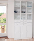 White cabinet with glass shelves beside a door with a golden retriever outside