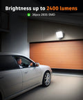 Heavy Duty Motion Sensor Outdoor Lights 30W LED Flood Lamp 2400 Lumens illuminating a garage entrance at night.