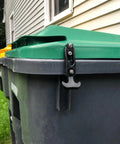 Rubber T-handle draw latch, black, side view securing green trash can lid.