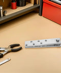 Heavy Duty Hidden Door Hinge Stainless Steel Pivot Hinge 360 Degree Rotation Load Bearing For Wood Doors And Cabinets Concealed Applications Built To Last With Smooth Quiet Operation on a workbench with tools and red toolbox in the background