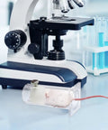 Acrylic Mouse Restrainer With Adjustable Sliding Plugs For Keeping 15 To 35 Gram Rodents Locked In During Procedures With No Fuss And Rock Solid Lab Setup next to a microscope.