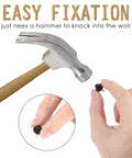 Holding Double Headed Push Pins For Picture Hanging And Photo Decor near a hammer, showing easy fixation.