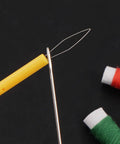 Close-up of needle threading a yellow 5 Pcs Needle Threader Set For Hand Sewing And Sewing Machines, Automatic Threading Device, with threads