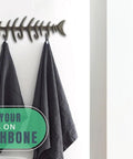 Heavy Duty Cast Iron Wall Hook Rack Featuring A Badass Fish Bone Skeleton Layout With Four Chunky Rustic Hooks and towels hanging.