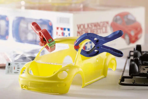 Microfix Mini Spring Clamp Set 7 Pcs For Delicate Tasks Model Makers And Hobbyists Secure Grip For Small Parts Handy Clamp Kit For Fiddly Work And Precise Assembly Ideal For Small Electronics Assembly And Craft Projects. Mini plastic spring clamps securing a yellow model car body for electronics and craft assembly.