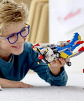 Child playing with Creator 3in1 Race Plane Build Kit With Helicopter And Jet Modes, 333-Piece Set, featuring open cockpit and rotating propeller.
