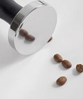Stainless Steel Espresso Tamper With Pressure Regulator For 51mm 54mm 58mm Portafilters beside coffee beans