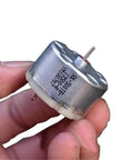 Close-up of Mini 32mm Round Spindle Motor, DC 6V 9V 12V, 5600 RPM, Carbon Brush Motor held in hand for small DIY projects.