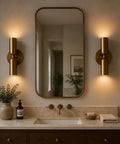 Modern Brass Wall Sconce – Mid Century Cylinder Up and Down Wall Light in elegant bathroom setting with mirror and decor.