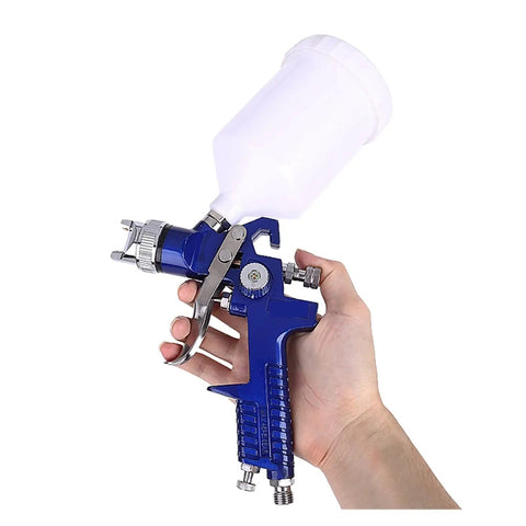 Slick Finish Handheld Airbrush Spray Gun Kit With Precision Nozzles Fine Mist Paint Sprayer held in hand showing copper flow cup.