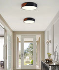 Sleek Modern Black Flush Mount Ceiling Light With 2 Lights, Mid Century Round Wood Accent Fixture in a hallway.