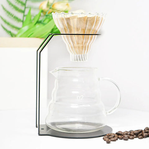 Top Shelf Iron Pour Over Coffee Dripper Rack With Rock Solid Frame Matte Black Filter Holder Stand and Precision Brewing Support For Home Cafe Kitchen Counter Setup with coffee dripper and glass carafe.