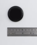 Heavy Duty Self Stick Furniture Sliders Round Two Inch Pads For Hardwood Floors No Sweat Setup Moves Large Couches And Tables With Ease Glides Like Butter Today, black round slider with ruler for size reference.