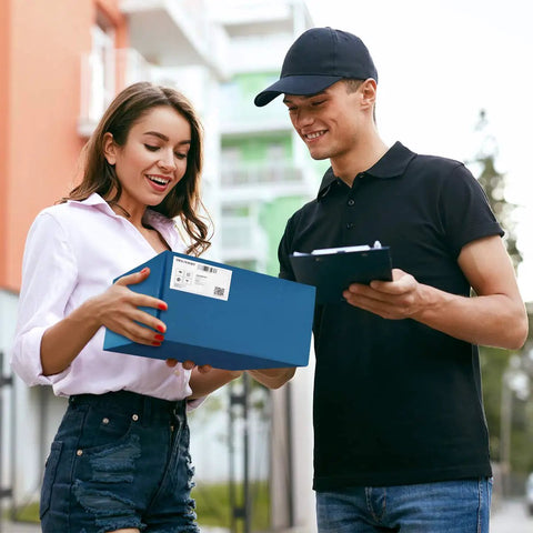 Woman receiving a package from a delivery person, representing navy blue poly mailers 12x15.5 inch 100 pack self sealing shipping bags.