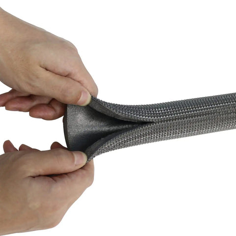 Hands compressing Pipe Insulation Tubing 1 Inch By 3 Eighth Inch Heat Preservation Insulated 6 Foot Length Two Handle Grips All Black Great For Hot Or Cold Pipes Reduces Noise And Energy Loss While Softening And Protecting Pipes