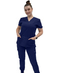Women's V Neck Scrub Top Delivering Killer Comfort And Sharp Navy Styling Crafted For Nurses Wanting Fresh Medical Uniform Looks. Model wearing navy scrub top with pockets.