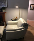Slim LED Floor Lamp With Adjustable Gooseneck Free Standing Corner Pole Light beside a sofa in living room, brass gold finish