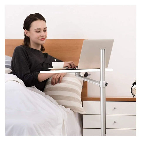 Adjustable Rolling Laptop Desk With Spacious Aluminum Top And Quick Height Adjustments used bedside, woman with laptop in bed.