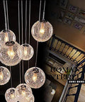Sleek Modern Stair Chandelier Featuring Glowing Round Glass Balls And White Metal Frame for dramatic lighting above staircase.