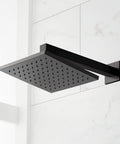 Slick Matte Black Hibiscus Thermostatic Shower System With 1.8 GPM Flow Control overhead shower head viewed against white tiles.