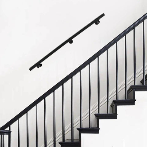 Kick Ass Heavy Duty Wall Mount Handrail in Matte Black Stainless Steel on wall beside indoor stairs for safe grip.