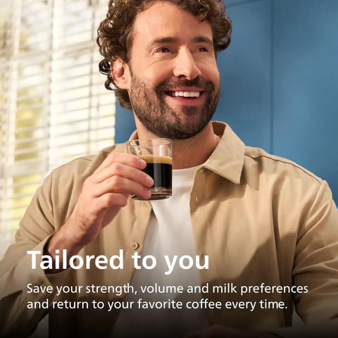 Man smiling and holding a glass of espresso, showcasing Fully Automatic Espresso Machine With 12 Hot And Iced Coffee Picks Straight Up Home Barista Game Changer Featuring Silent Brew Tech Auto Milk Foam And Ceramic Grinder For Smooth Daily Sips In Glossy Black Chrome.