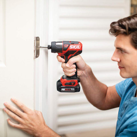 Man using 12V Cordless Drill Driver And One Quarter Inch Hex Impact Combo Kit With Two 2.0Ah PW Core 12 Batteries And Charger on door hinge