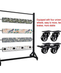 Heavy Duty Rolling Fabric Display Rack With Adjustable Cloth Roll Poles And Casters showcasing four patterned rolls and durable wheels.