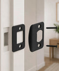 Universal Door Strike Shim Kit, three black stainless steel spacer plates and screws on a door frame.