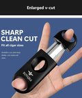 Front view of a Royga cigar cutter with stainless steel blades and black housing, held in a hand; enlarged V-cut design and logo visible