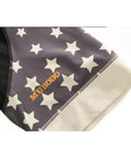 Close-up of a fabric sleeve with white stars on a gray background and 'MUBODO' in orange letters, showing stitching detail.