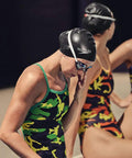 Swimmer wearing Go-To Unisex Silicone Swim Cap For Adults in black, preparing for training or racing at the poolside.