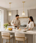 Brushed Gold Crystal Pendant Light With Adjustable Rods And Sloped Ceiling Mount No Sweat Install hangs over a kitchen island.